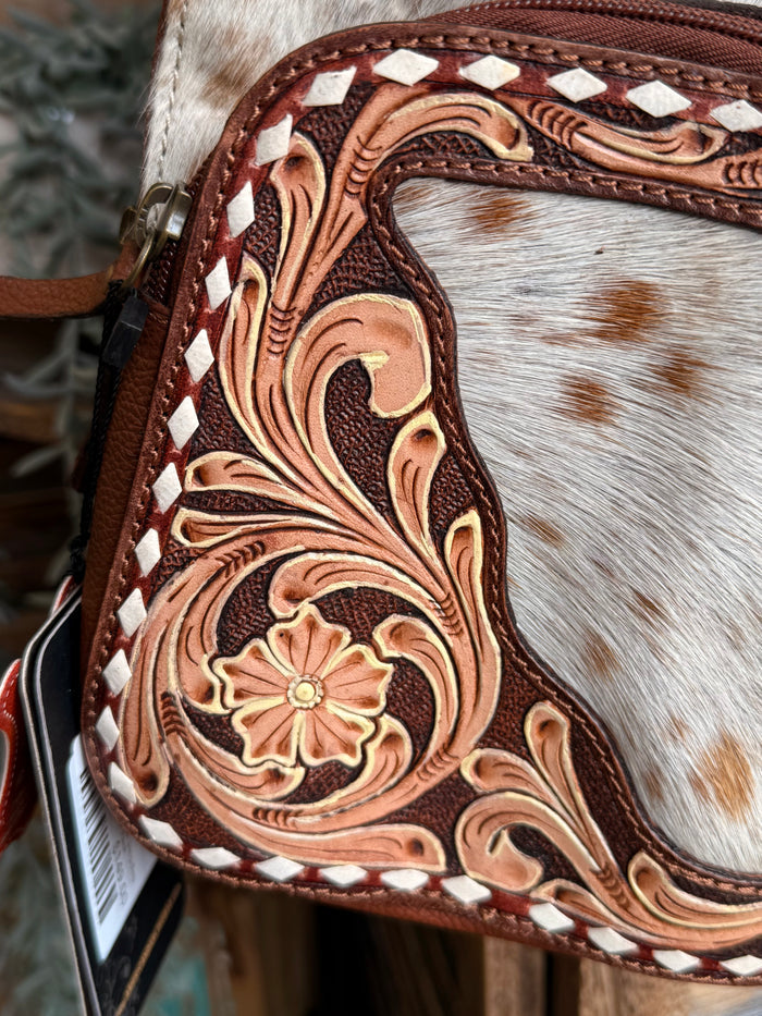 Tooled brown floral leather pattern on hair-on cowhide backpack pocket