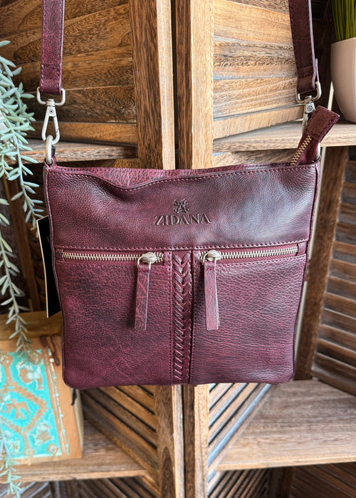 Plum double-pocket leather crossbody bag with front zip pockets and logo panel