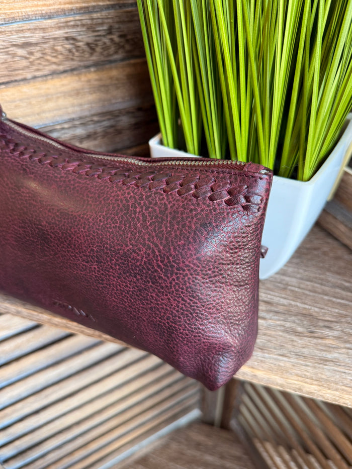 Plum mini wristlet pouch with textured finish, zip top, and wrist strap