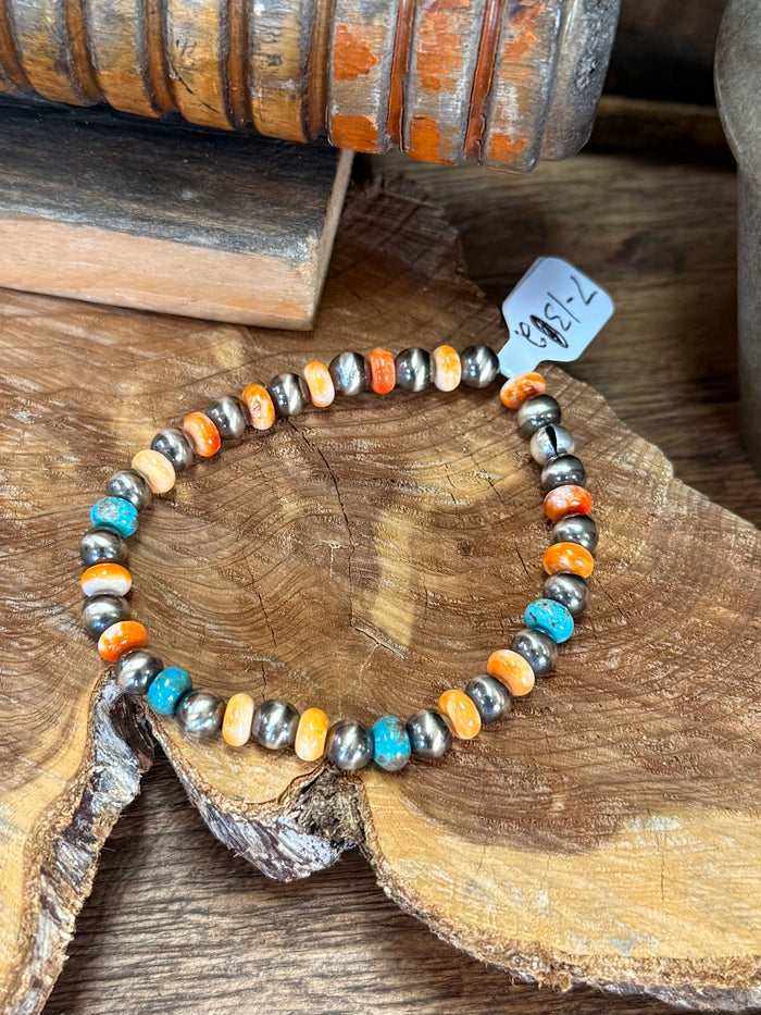 Stretch beaded bracelet featuring turquoise, orange and white shell pearls with silver accents