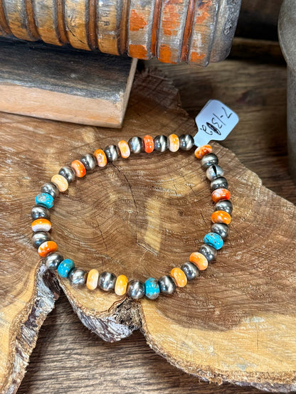 Stretch beaded bracelet featuring turquoise, orange and white shell pearls with silver accents