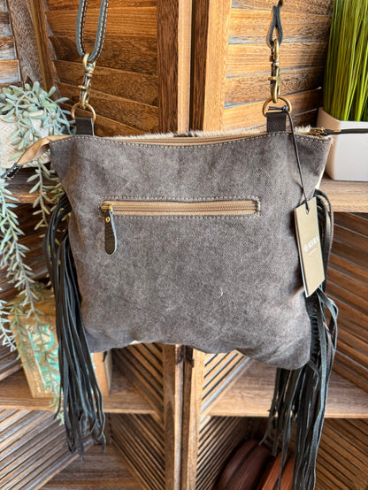 Gray leather purse with front zipper pocket and long black fringe, crossbody straps