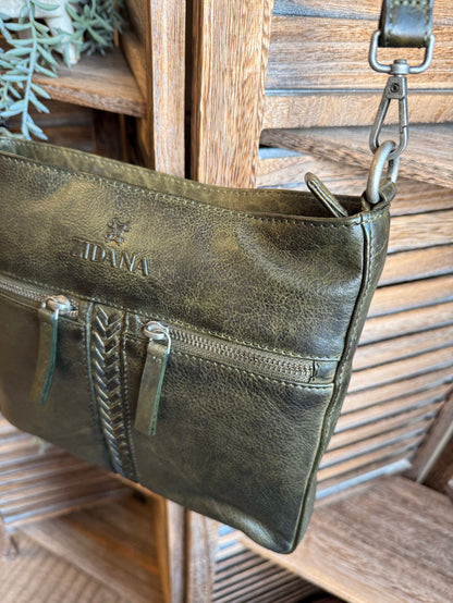 Olive leather crossbody bag angled view with braided center zipper and left side pocket.