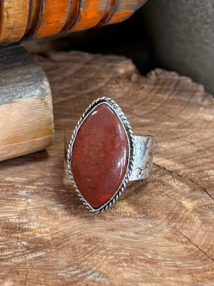 Adjustable silver-tone ring with large oval red stone and textured rope-edge band