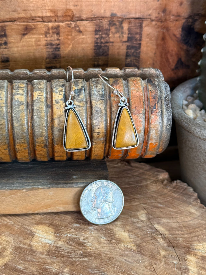 Silver fishhook earrings with teardrop yellow stone; coin shown for size scale
