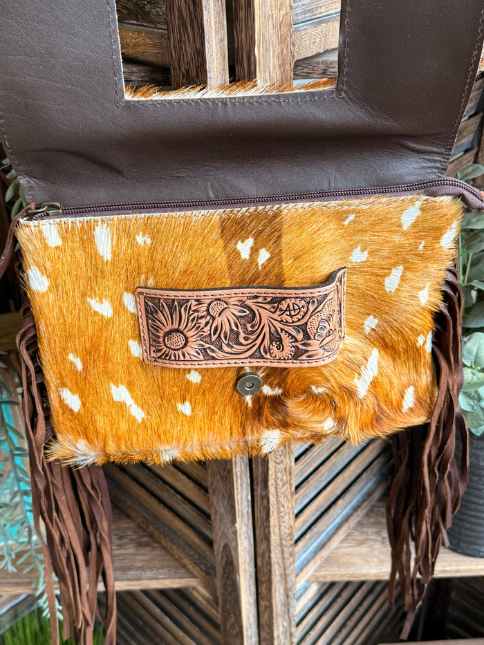 Cowhide crossbody clutch with white spots, engraved patch front, button closure, fringe