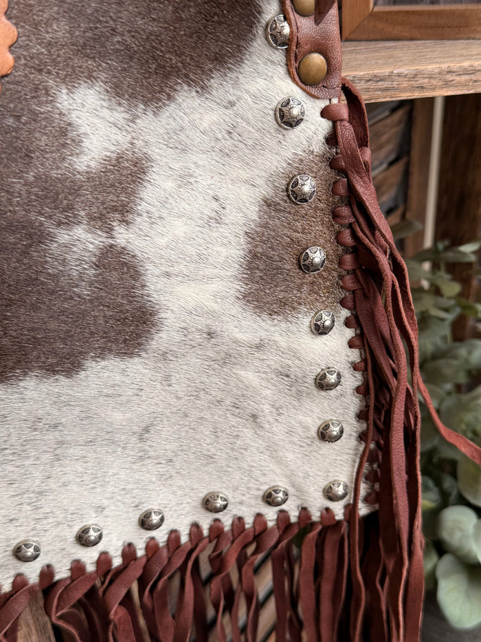 Cowhide crossbody purse edge with silver stud accents and reddish leather fringe