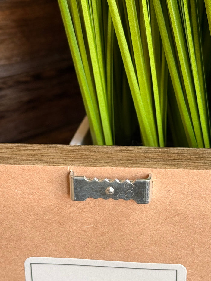 Framed artwork hanging hardware with metal latch and corner detail