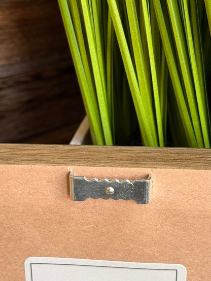 Framed artwork hanging hardware with metal latch and corner detail