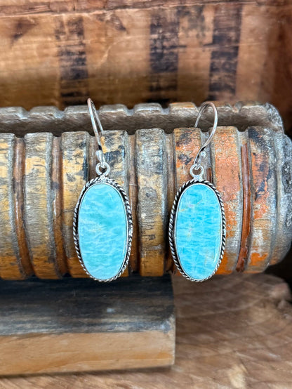 Silver fishhook drop earrings, oval bright blue stone with scalloped bezel