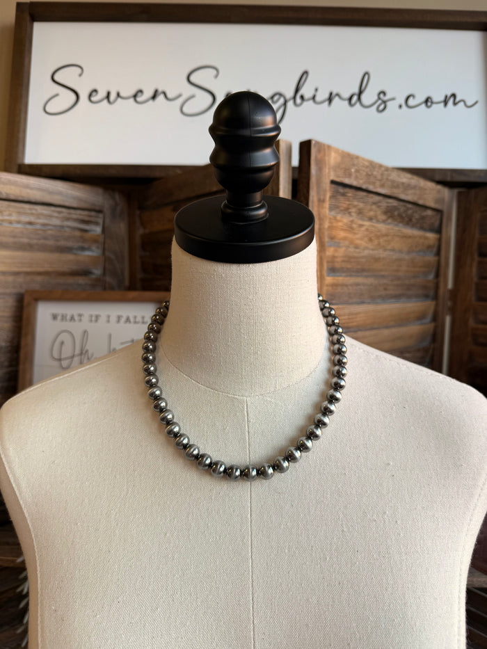 Silver pearl bead necklace on mannequin, round beads in a single strand