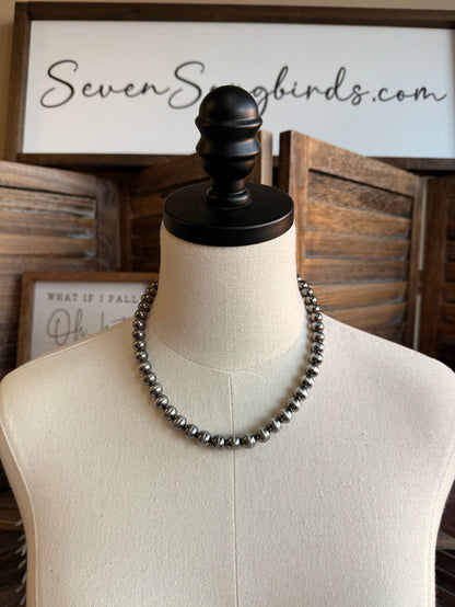 Silver pearl bead necklace on mannequin, round beads in a single strand