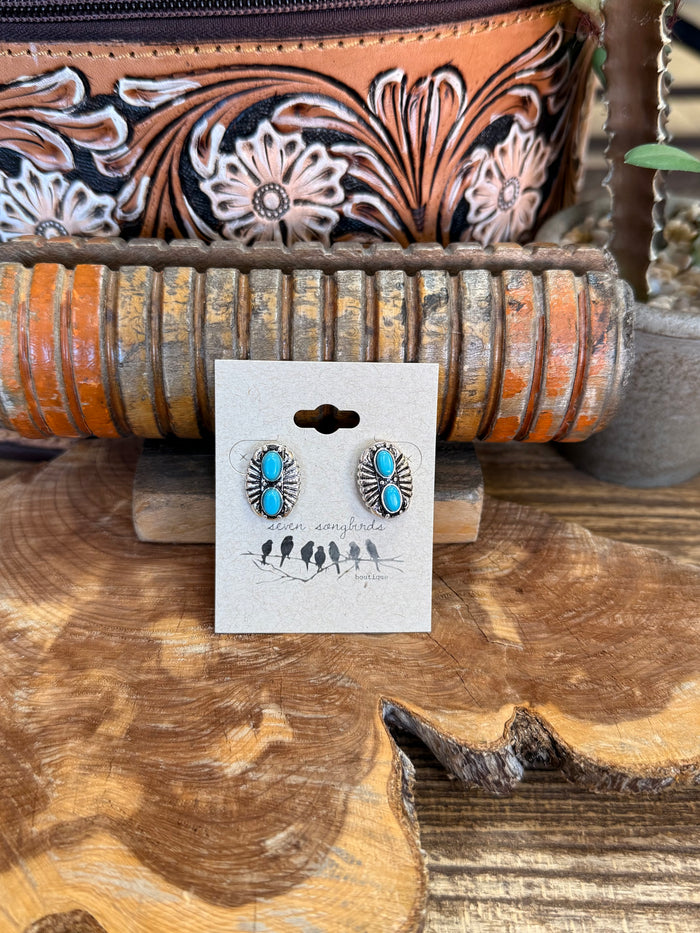 Silver-tone turquoise double concho stud earrings with oval stones, on display card