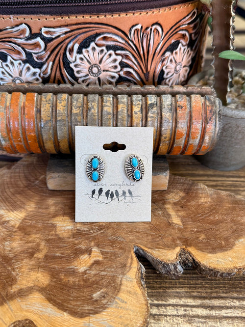 Silver-tone turquoise double concho stud earrings with oval stones, on display card