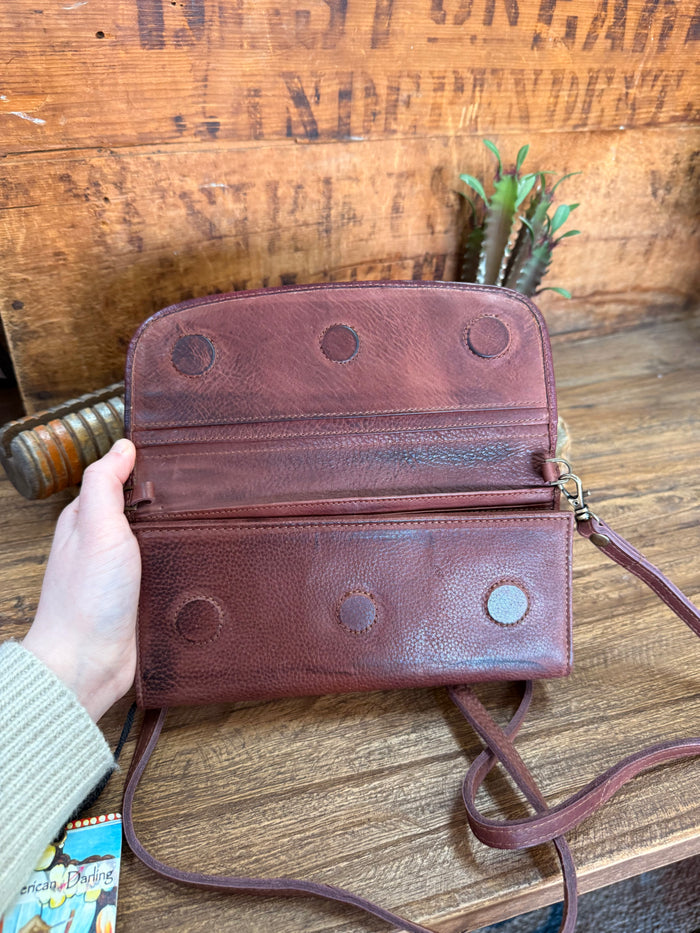 Burgundy leather crossbody wallet with snap flap and metal chain strap loops