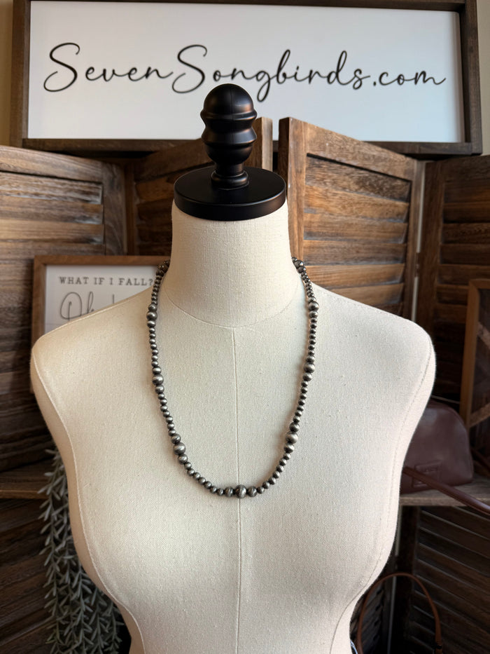 Triple pearl stack necklace with silver-tone beaded strands, layered three-row design
