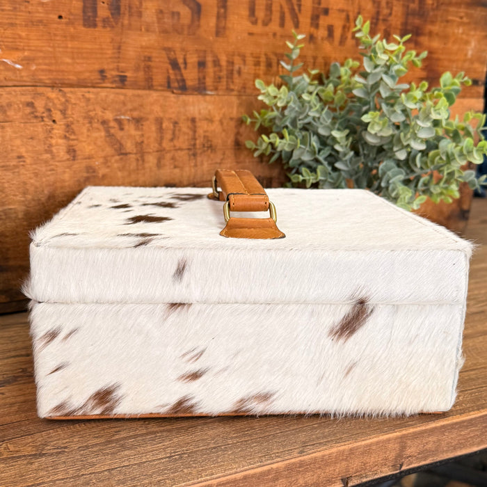 Hair-on cowhide jewelry box with tan leather latch and spotted hide top