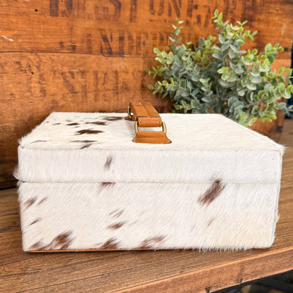 Hair-on cowhide jewelry box with tan leather latch and spotted hide top