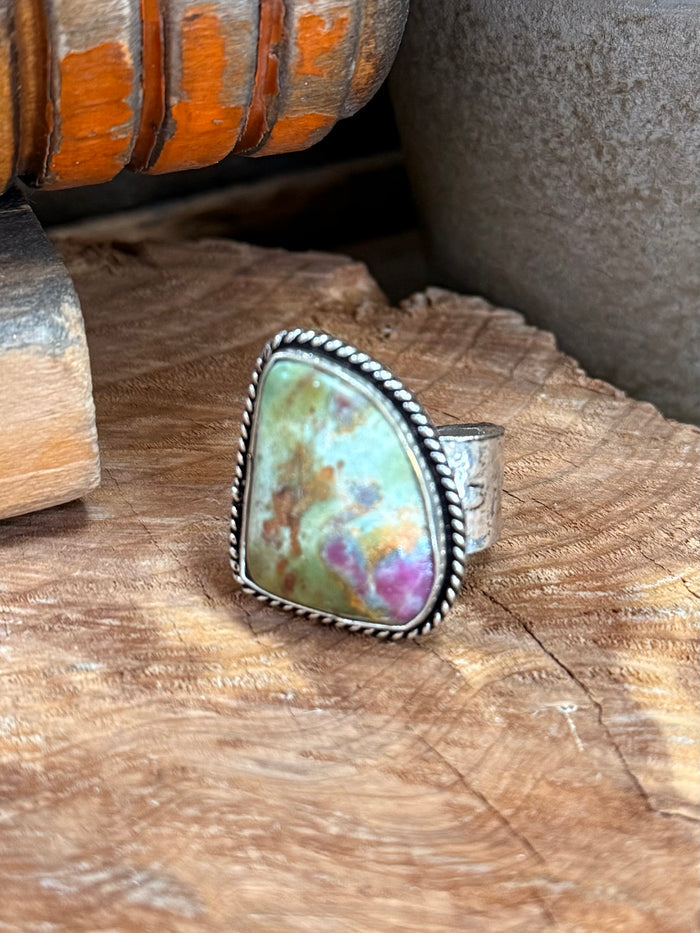 Adjustable silver-tone ring with oval iridescent cabochon and textured bezel setting