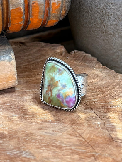 Adjustable silver-tone ring with oval iridescent cabochon and textured bezel setting