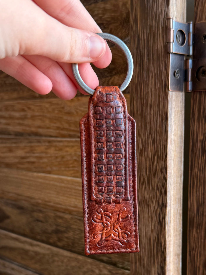 Rusty brown braided-style leather keychain tag with embossed grid and emblem, metal key ring