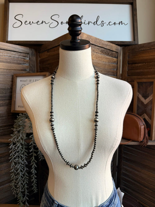 Mixed silver pearl bead necklace on a mannequin, long layered bead strand design