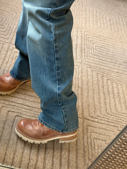 Mid-wash blue jeans with cuffed hem and contrast stitching at the bottom.