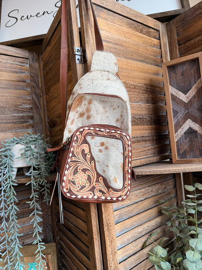 Hair-on cowhide sling backpack with floral tooled front pocket