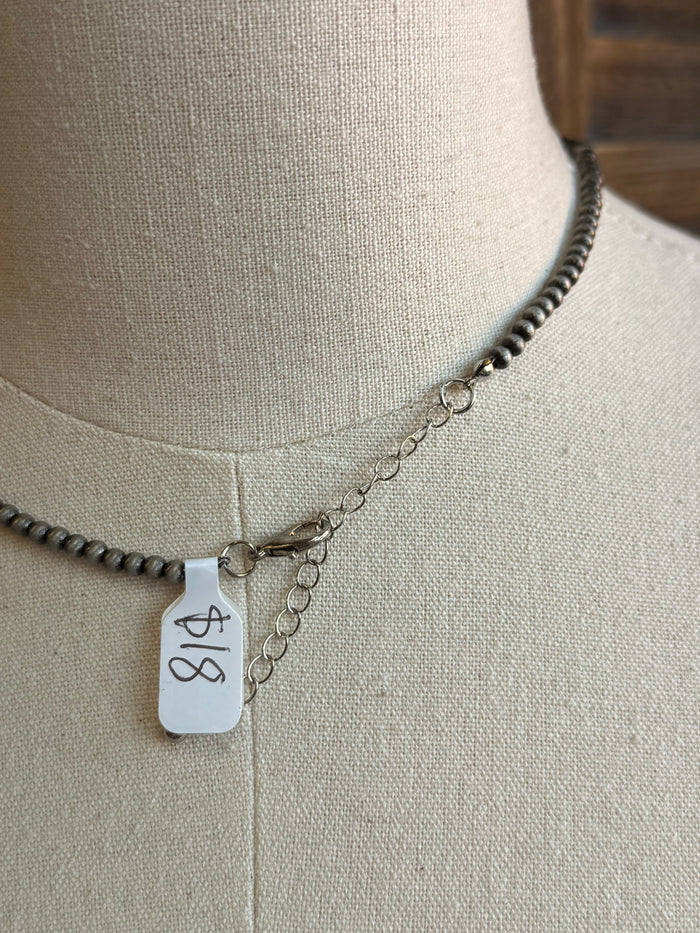 Silver pearl necklace with square hangtag marked '18' and small extender chain