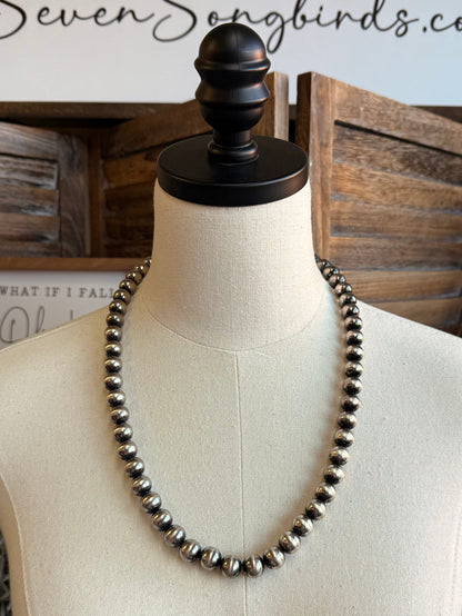 Silver pearl bead necklace laid in a long U shape on mannequin