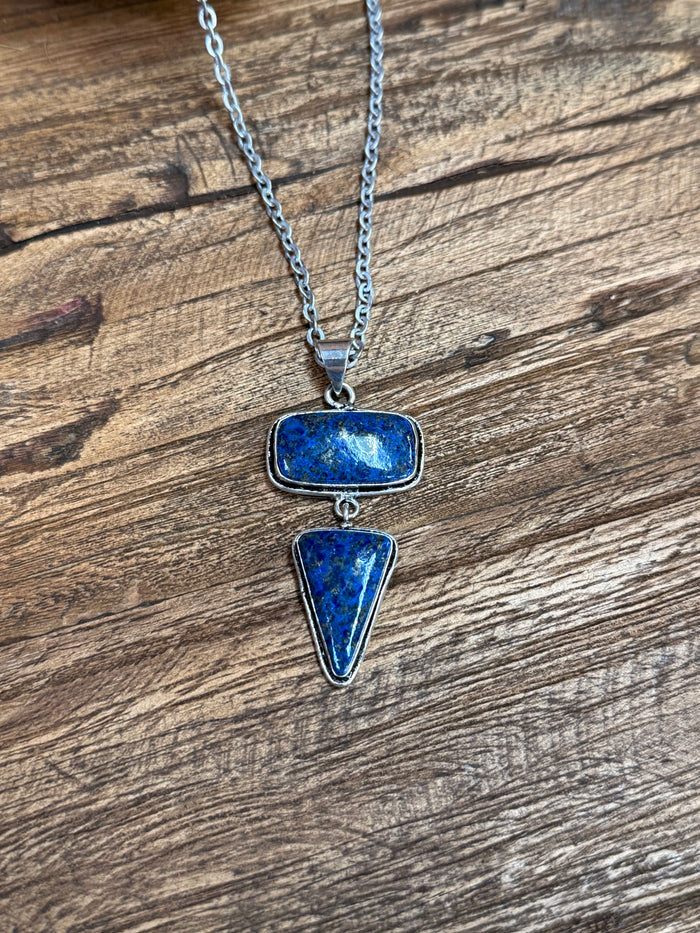 Silver lariat necklace with blue oval centerpiece and teardrop drop pendant