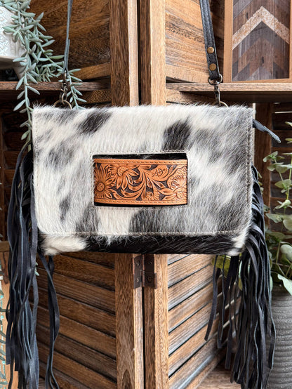 Cowhide crossbody clutch with ornate tan leather front panel and long black fringe