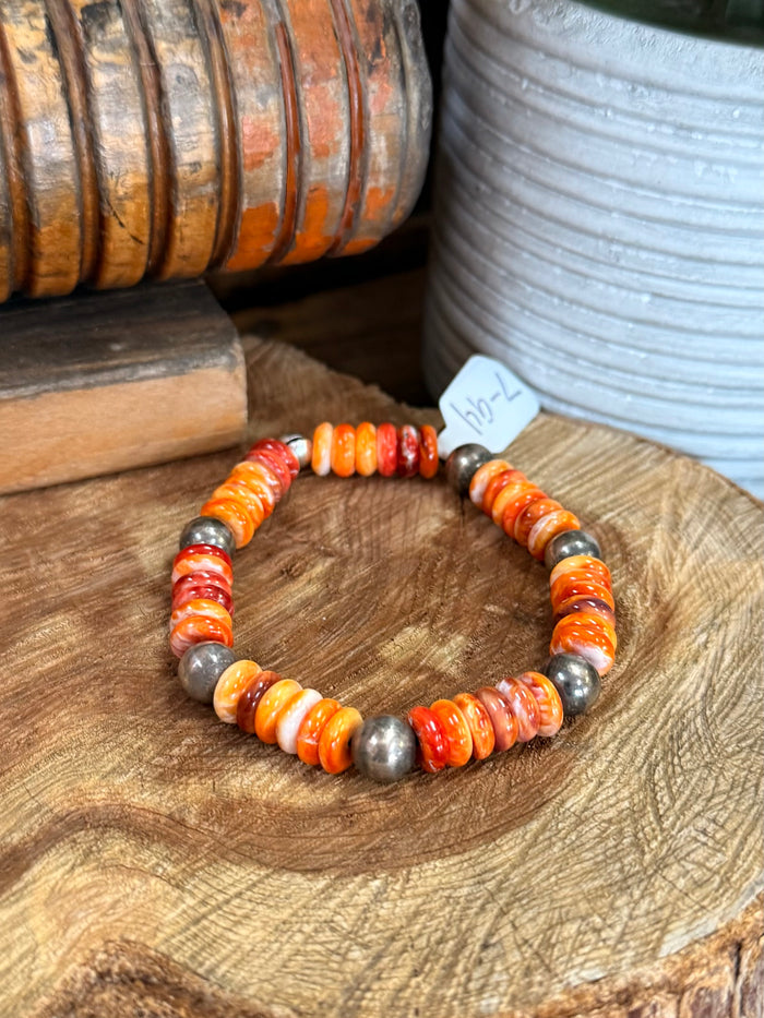 Stretch beaded bracelet featuring orange, white, and silver-toned chunky beads on elastic cord
