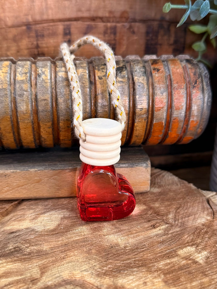 Heart-shaped scent diffuser bottle with red glass and braided hanging loop