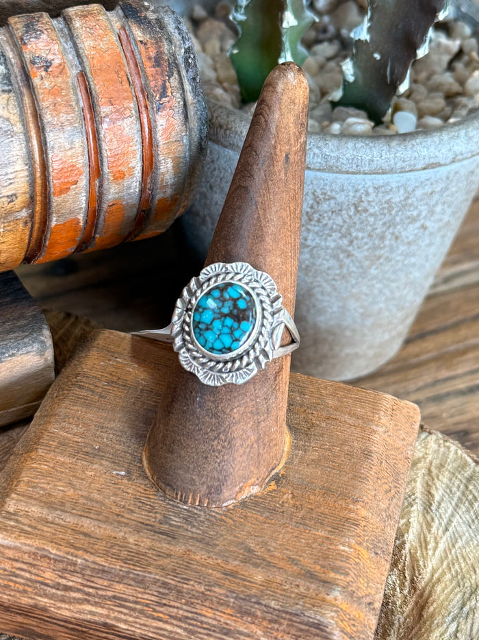 Turquoise oval spiderweb silver ring with rope-edge band, side view