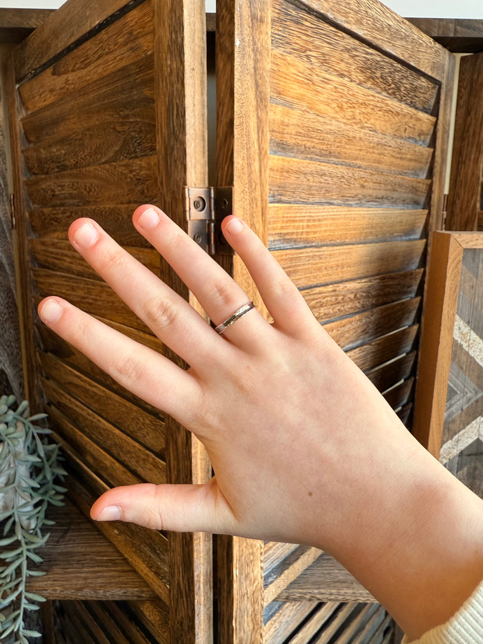 Hammered sterling silver ring on hand, slim band with textured shine