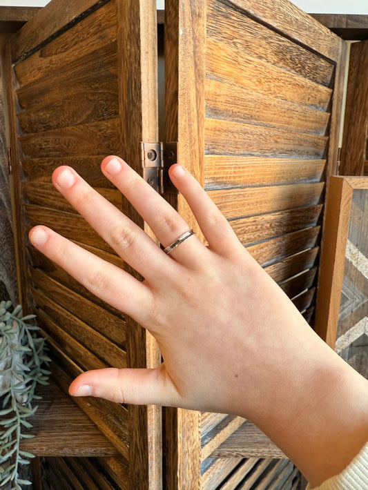 Hammered sterling silver ring on hand, slim band with textured shine