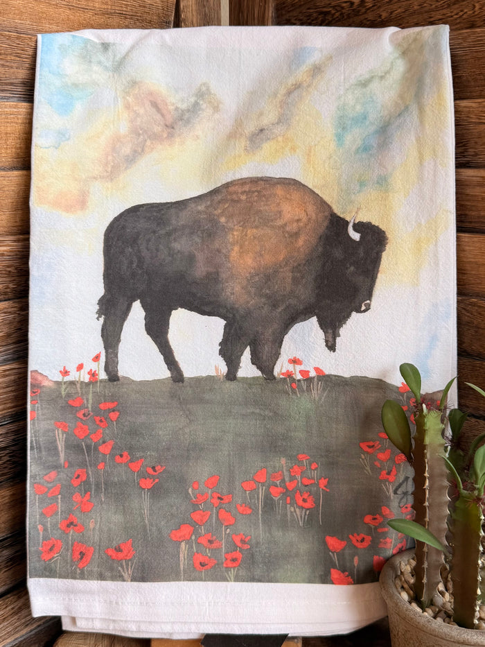 Tea towel featuring a dark buffalo against a light watercolor sky with red poppies