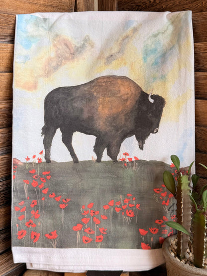 Tea towel featuring a dark buffalo against a light watercolor sky with red poppies