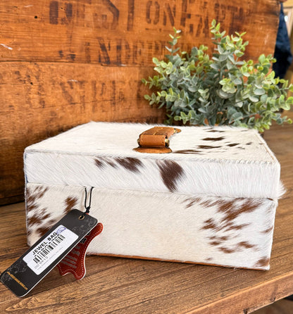Hair-on cowhide jewelry box with tan leather latch and brown-and-white hide pattern