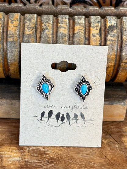 Turquoise and silver diamond stud earrings with blue center stones, ornate borders