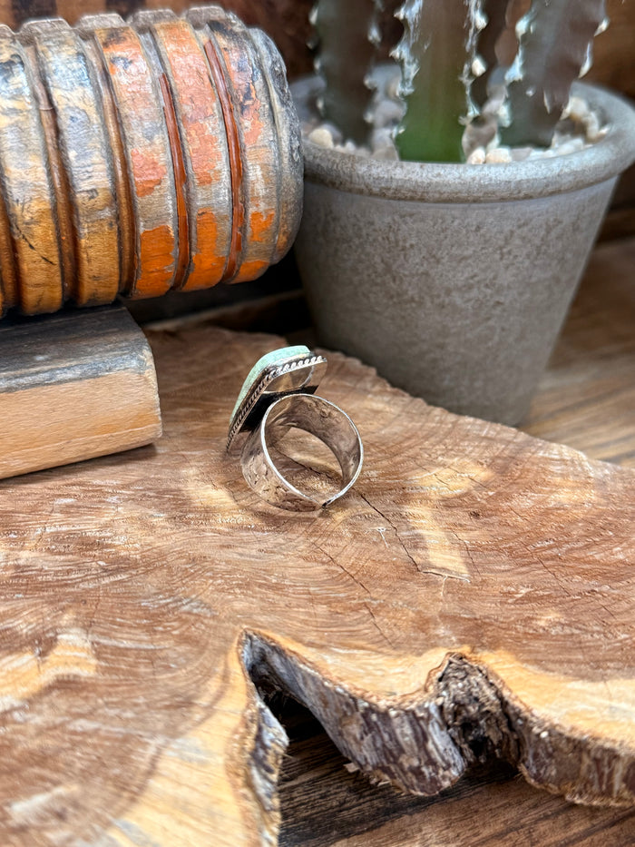 Open adjustable silver-tone ring with oval turquoise-green stone and bezel
