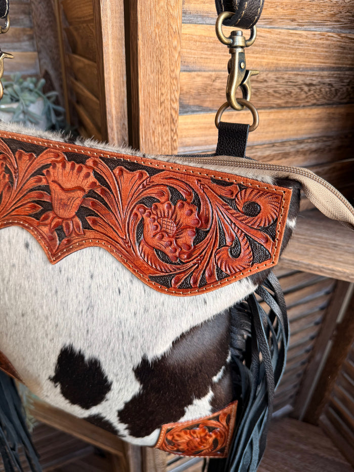 Cowhide purse with carved orange leather top trim and black fringe, side view
