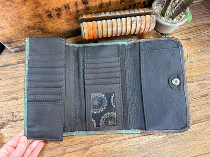 Leather wallet interior with card slots and lined bill pockets, patterned center pouch