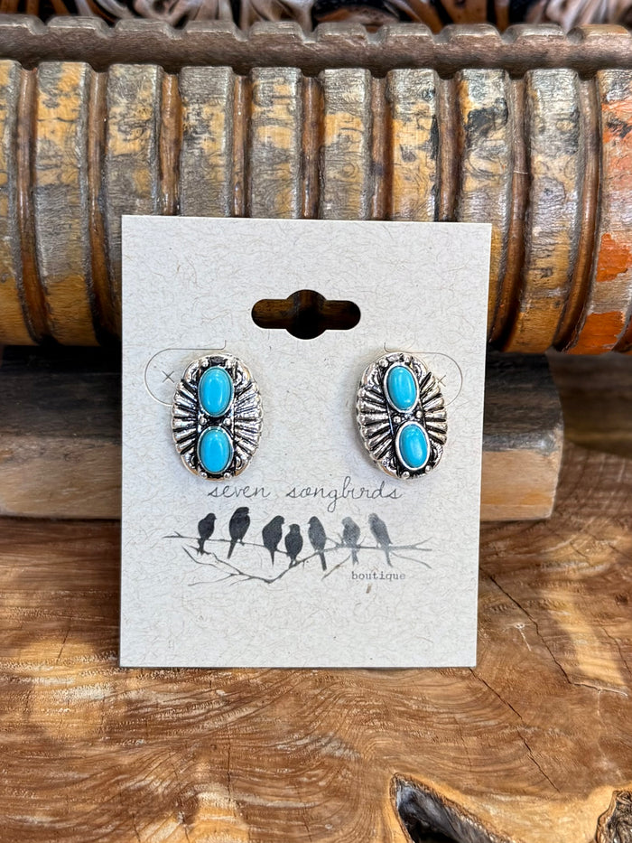 Silver-tone turquoise double concho stud earrings with oval stones, close-up on card