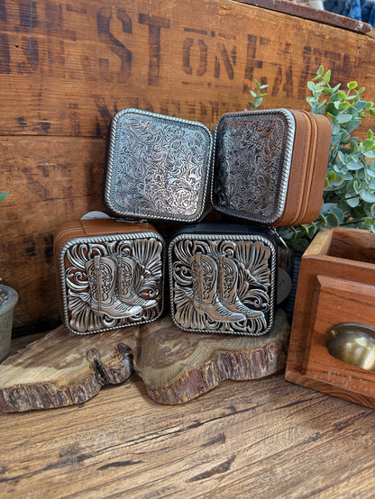 Small engraved metal travel jewelry box with hinged dark lid, silver scroll pattern
