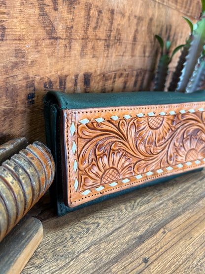 Green leather wallet corner with brown hand-tooled floral design and decorative lace border