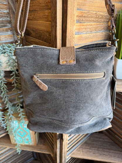 Dark gray canvas crossbody bag with brown leather strap and front zip pocket