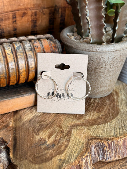 Sterling silver twisted-rope large round hoop earrings, visible on display card