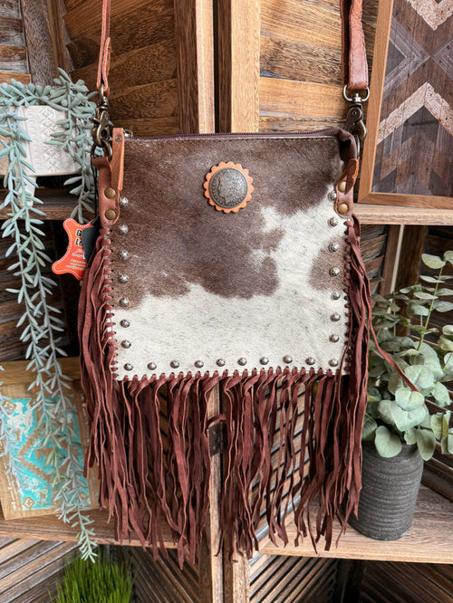 Fringed cowhide coin crossbody bag with concho, silver studs, and long leather fringe